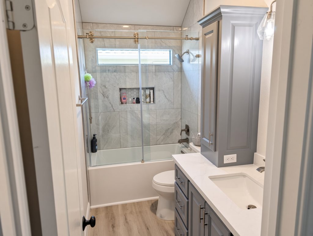 Guest bathroom remodel The Woodlands — deep soaking tub and shower with large-format tile and niche