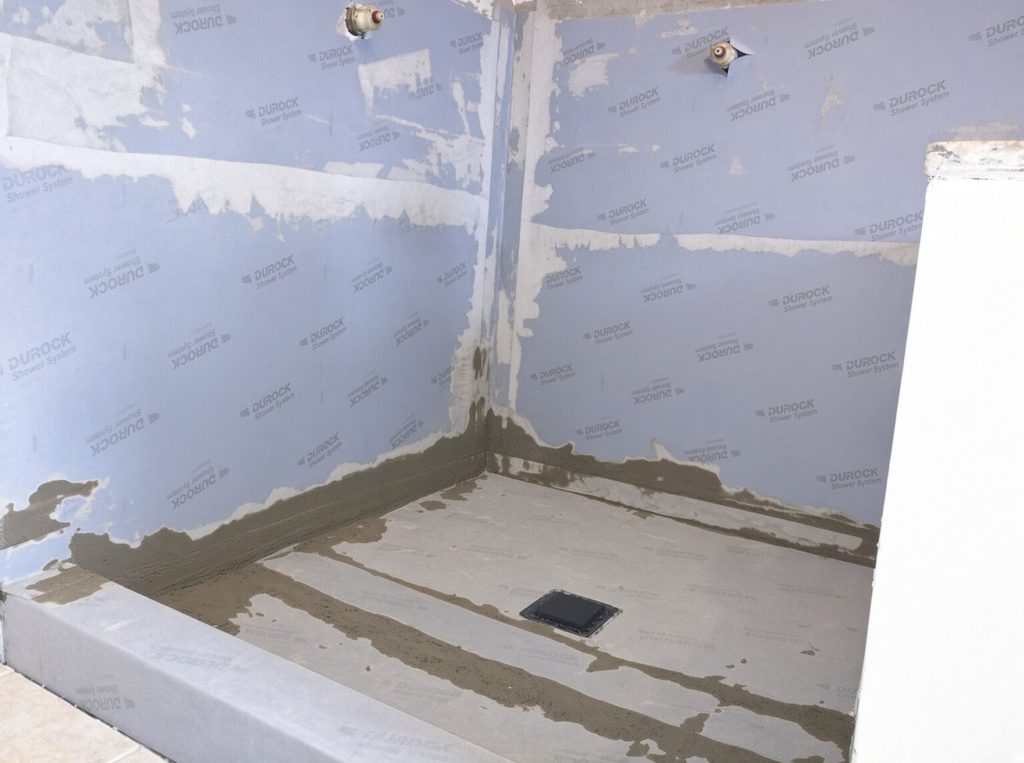 Schluter-style waterproofing and RedGard in master shower remodel over garage