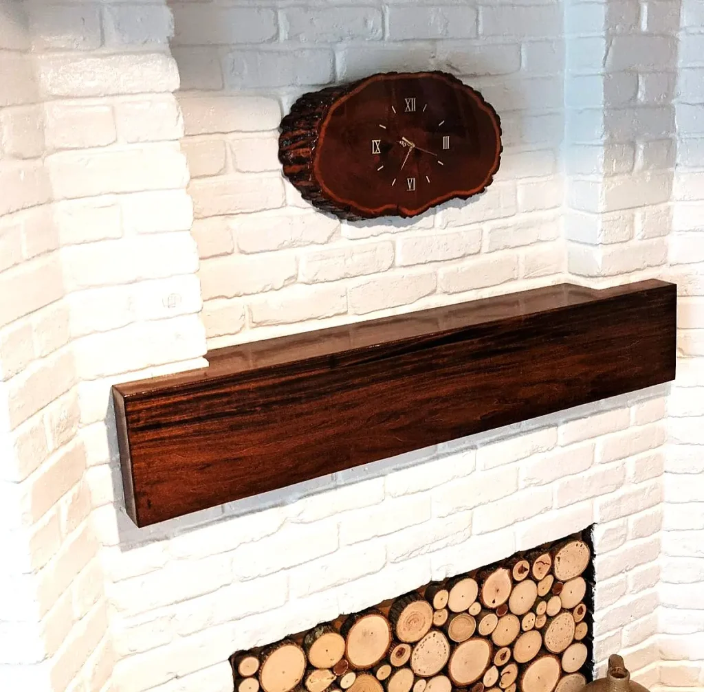 Custom maple faux beam fireplace mantel scribed into a stepped white-brick wall in Spring, Texas.