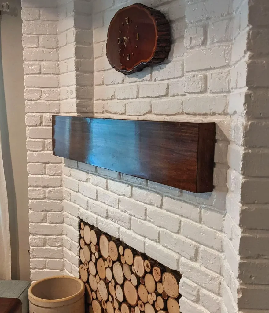 Maple faux beam mantel fitted to a multi-level painted brick fireplace with a recessed center.