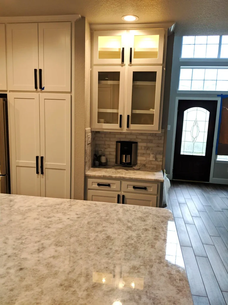 Kitchen coffee bar with wall-mounted coffee maker and storage drawers.