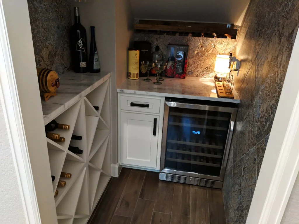 Dry bar under the stairs with wine fridge and bottle storage.