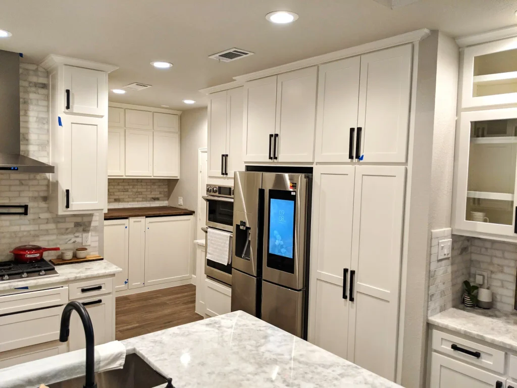Same kitchen built — fridge wall, wall ovens, and pantry cabinets in Spring, Texas.