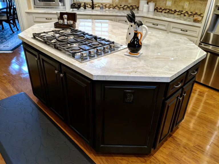 Black kitchen island with a built-in gas cooktop and light stone countertop, Estates at Windrush, Spring TX