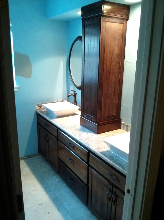 Custom double vanity with vessel sinks and a stained linen tower between the sinks, Spring TX